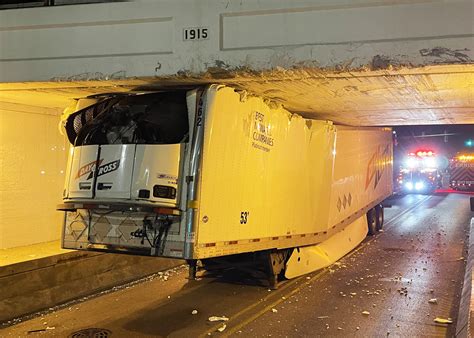 semi truck stuck under bridge